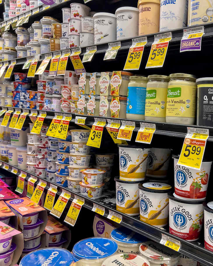 persona comparando precios de alimentos en estanterías de supermercado