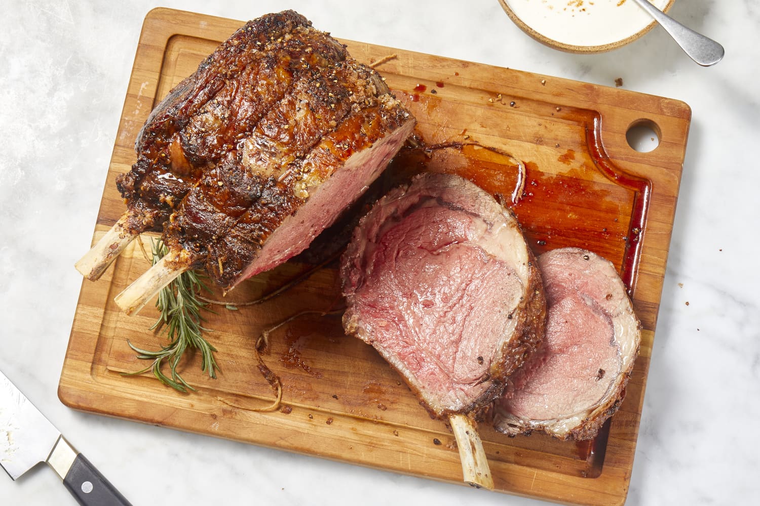 Chef de-boning and carving a portion of barbecued prime rib steak