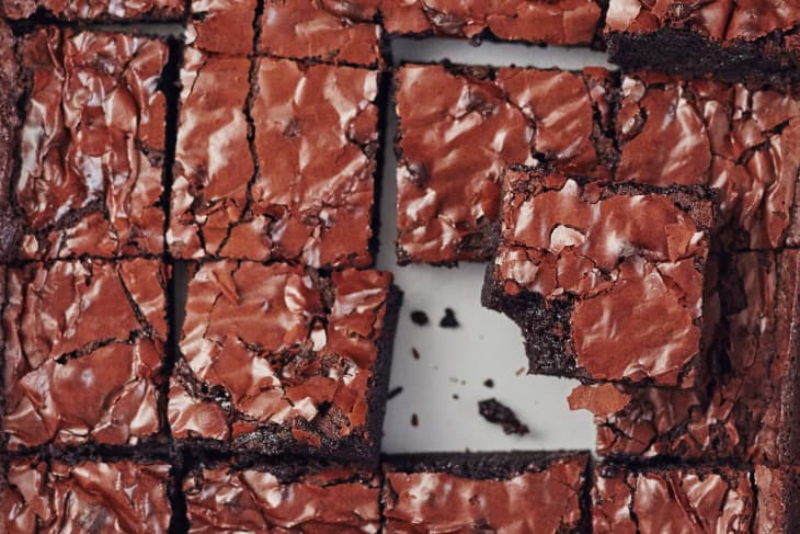 Fudgy chocolate brownies with a shiny, cracked top, cut into squares.
