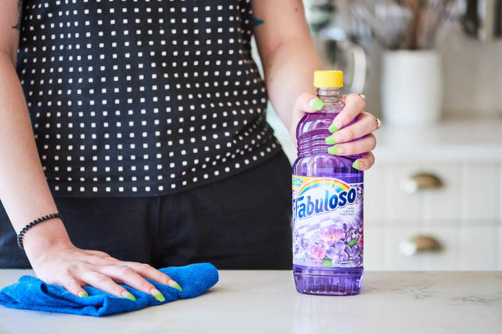 woman holding fabuloso cleaner in kitchen