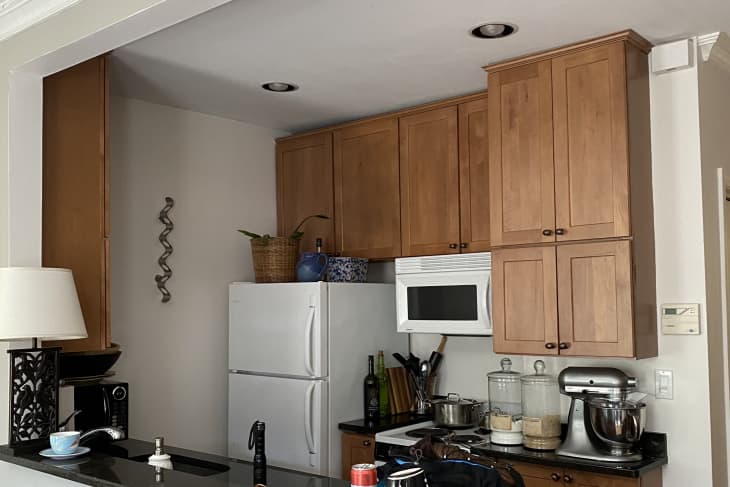Before: kitchen with brown cabinets and black counters