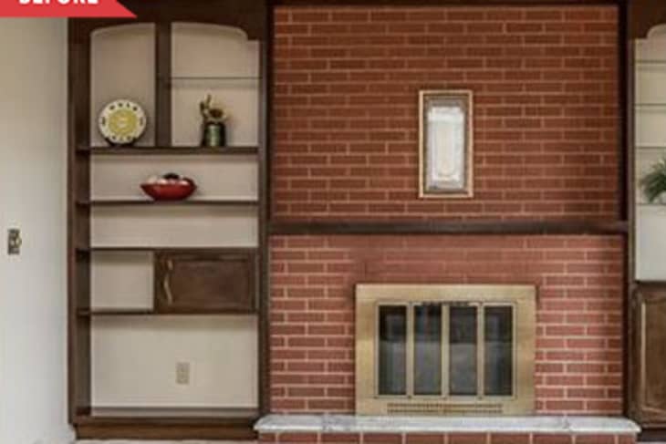 Before: red brick fireplace with wood shelving on the sides and a brass fireplace insert