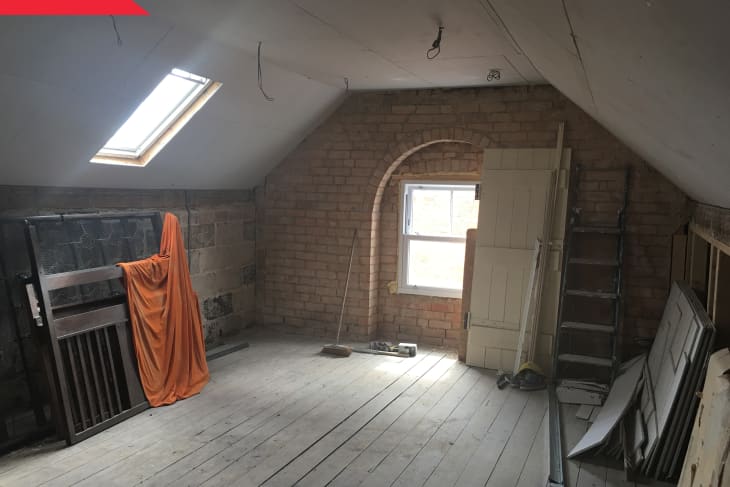 Before: attic with brick walls and dingy wood floors