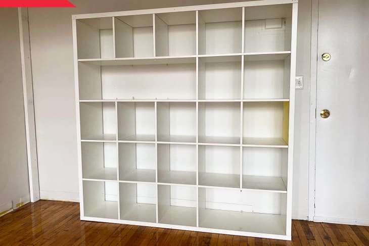 Before: Empty white IKEA KALLAX 5-by-5 cube shelf