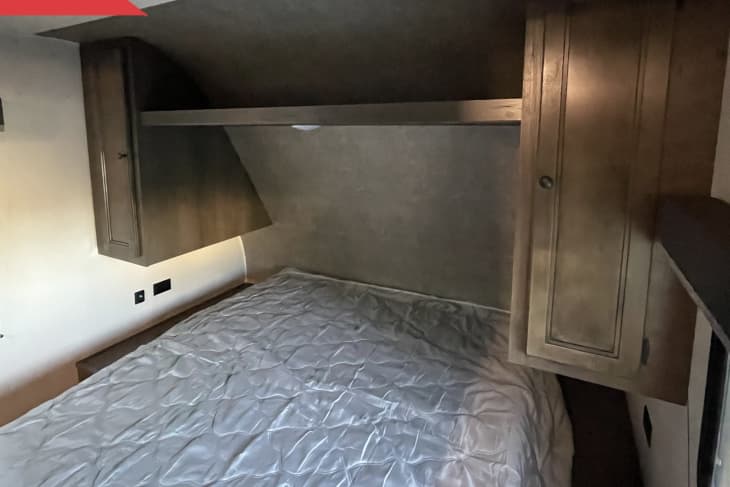 Before: Old mattress in brown, dated sleeping area in RV