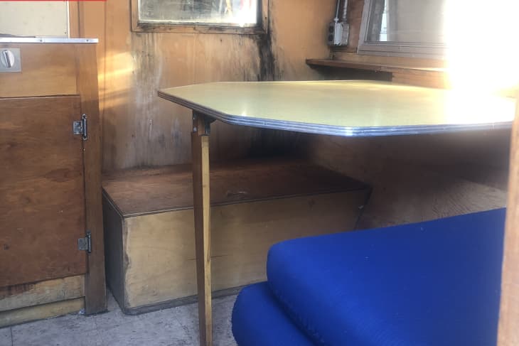 Before: Dated camper with worn wood interior