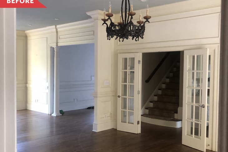 Before: Traditional dining room with brown wood floors and white walls, plus a black chandelier