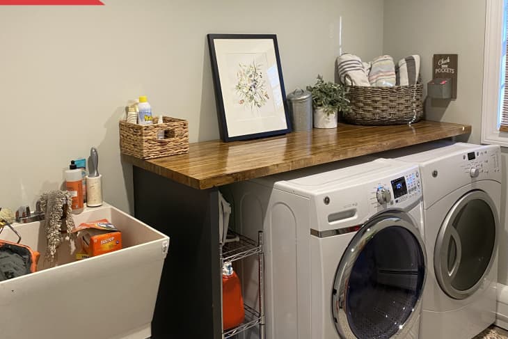 Before: beige laundry room with utility sink and wood counter over the washer and dryer