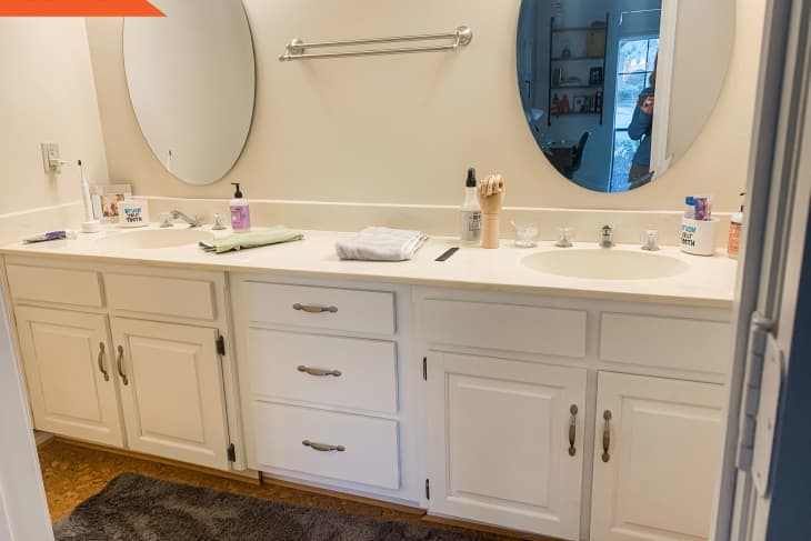 Double sink with oval mirrors and white cabinets