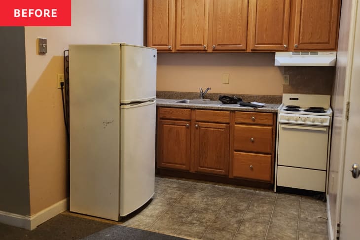 Kitchen and entry area of studio apartment. No furnishings, dated wood cabinets