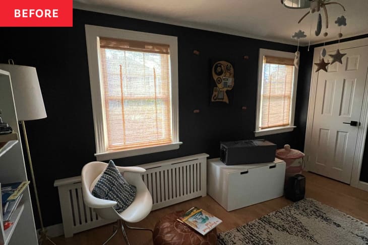 Nursery before renovation/makeover: black walls, wood floor, white furniture and bookshelves, some arts,