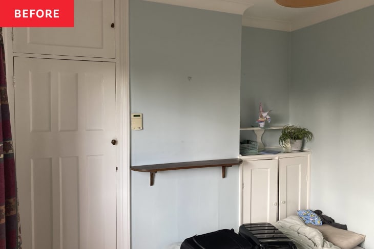 blue walls in a bare room with floating shelf on wall and built in cabinets
