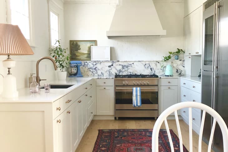 Kitchen with marble backsplash, lamp, and red vintage rug