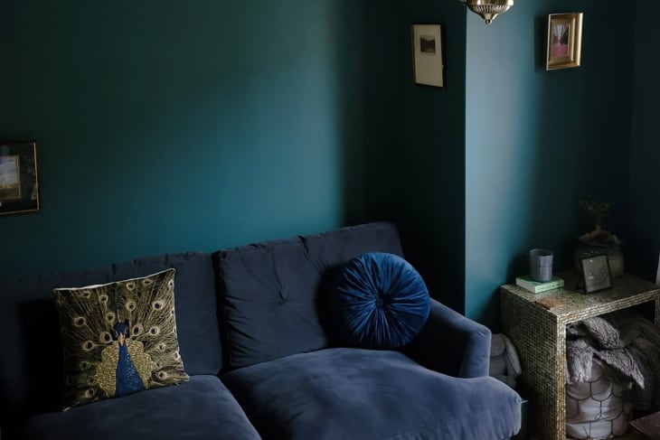 Living room with deep green walls and navy sofa