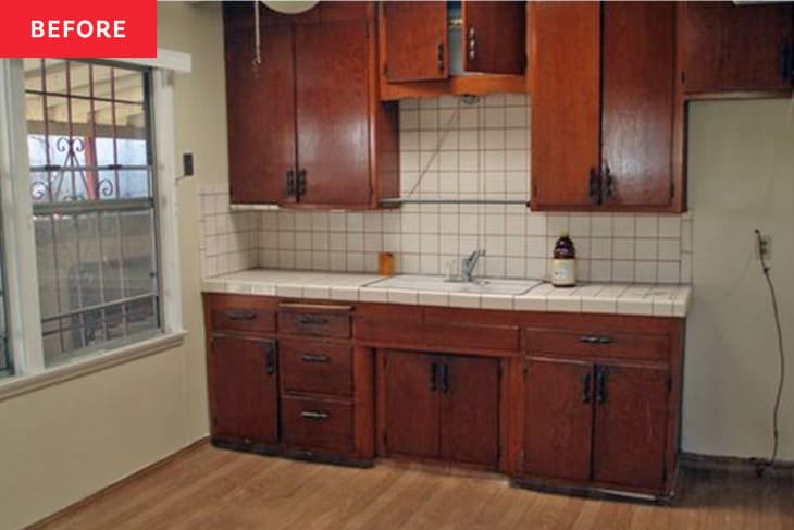 outdated kitchen with square tile backsplash and red stained wood cabinets before renovation