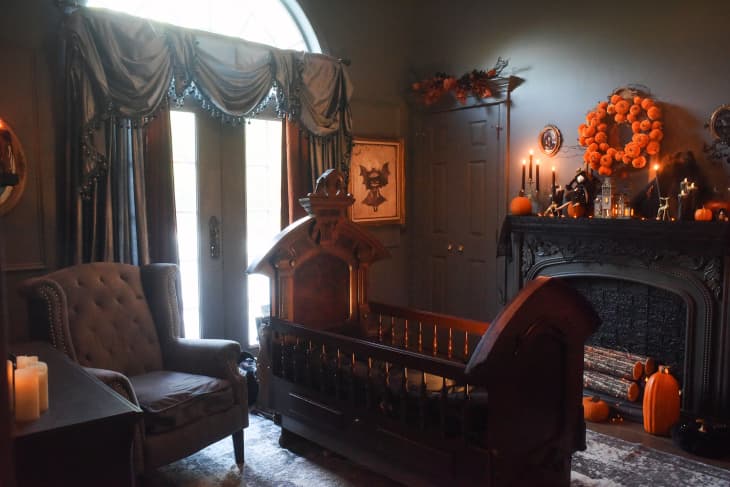 Gothic baby crib in bedroom with fireplace.