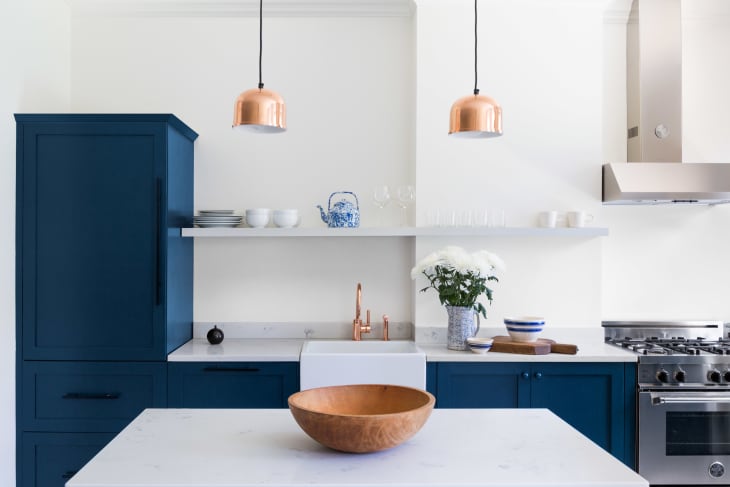 a white kitchen with blue cabinets