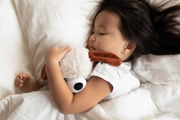 Young girl sleeping with stuffed animal