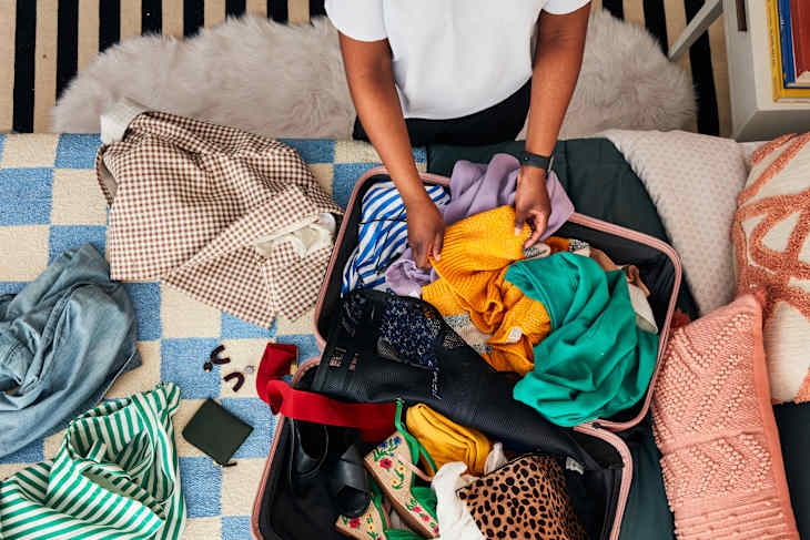 shot of someone folding clothes in a suitcase