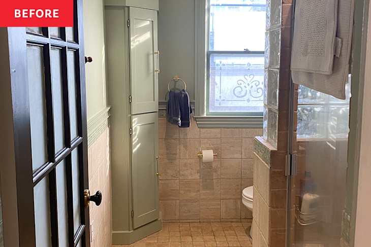 Bathroom with light green walls, a glass shower, beige tiles, a toilet, and a towel hanging by a window.