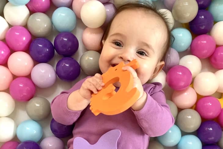 Baby playing in homemade ball pit that's been crafted from an IKEA STUBB storage case