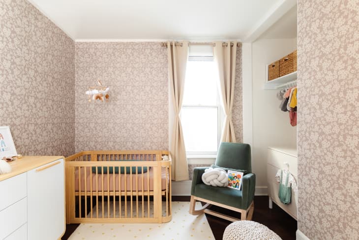 Newly decorated nursery with taupe floral wallpaper.