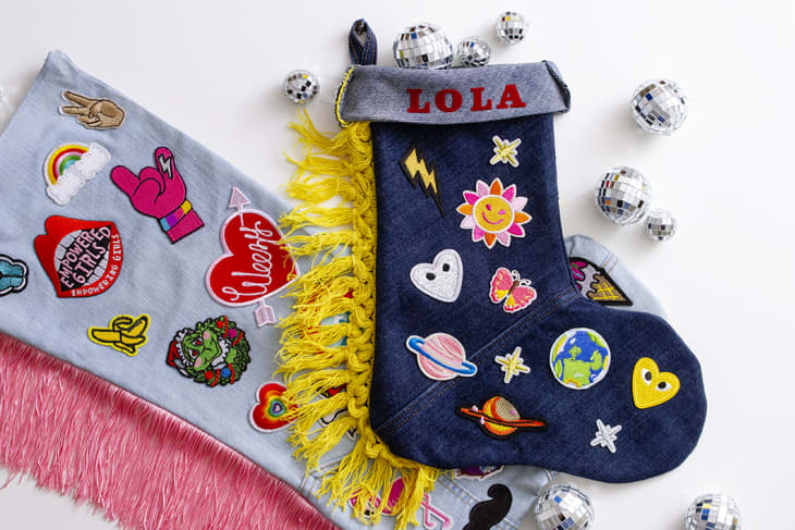 two holiday stockings with name "Lola" and decals (planets, flowers, suns).