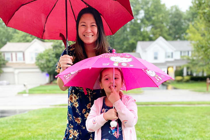 mother and daughter with umbrellas in the rain