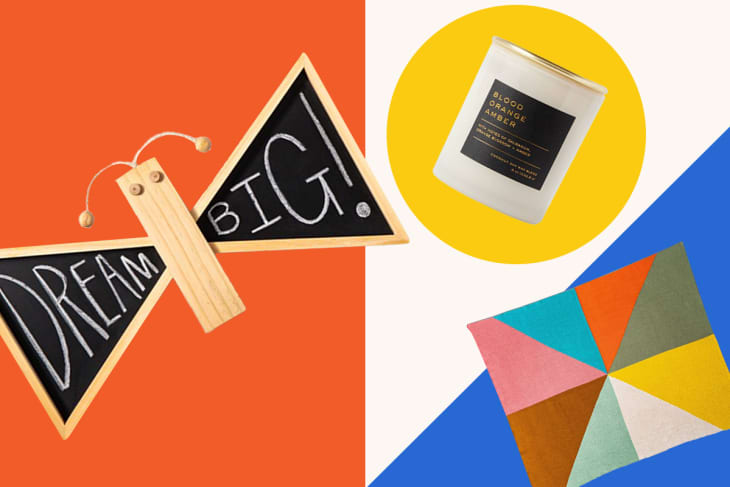 Butterfly-shaped chalkboard with "Dream Big," a candle labeled "Blood Orange Amber," and a colorful geometric rug.