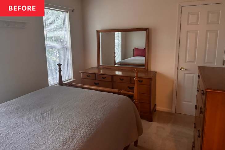 A cozy bedroom featuring a wooden bed frame, dresser with a mirror, and a window with blinds.