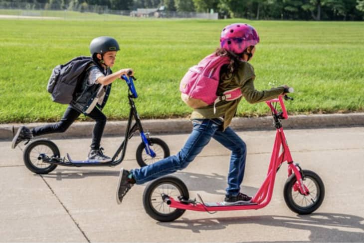 Two kids on black and pink Mongoose scooter