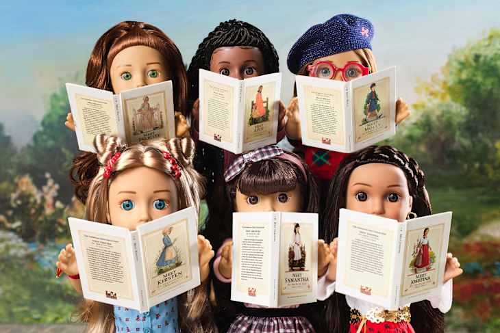 Modern American Girl dolls reading books.