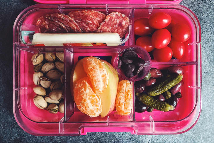 Pink Yumbox lunchbox with a variety of foods