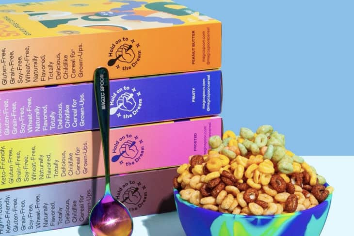 four cereal boxes and multicolored bowl and spoon