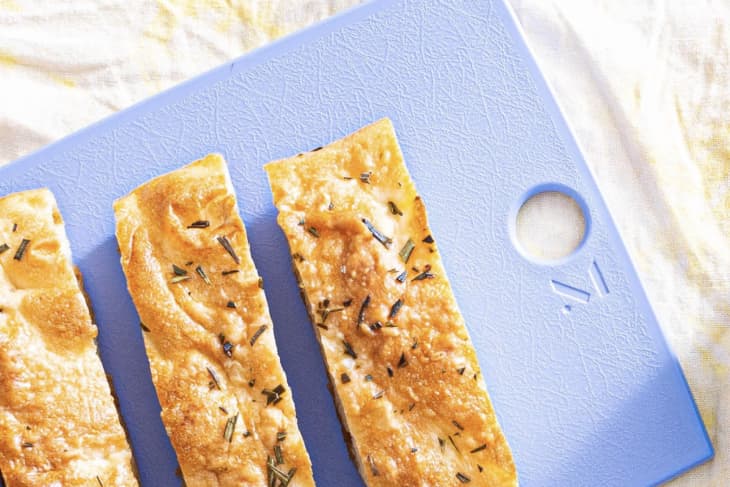 blue cutting board holding bread