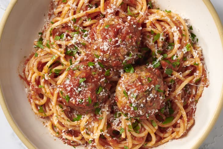 spaghetti and meatballs in bowl garnished