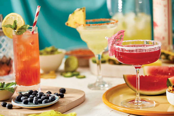 Cocktails on surface with fruit around from Y'ALL EAT YET? by Miranda Lambert with Holly Gleason. Copyright © 2023 by Miranda Lambert. Reprinted by permission of Dey Street Books, an imprint of HarperCollins Publishers.
