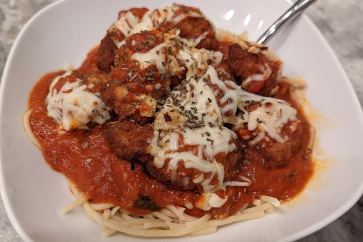 Spaghetti with chicken parmesan on top.