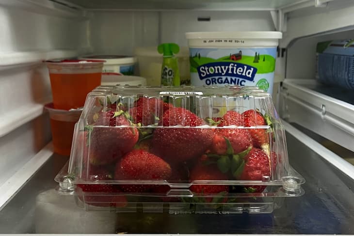 Strawberries stored upside down in plastic container.