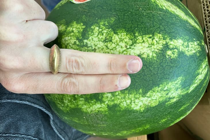 Someone with two fingers over watermelon