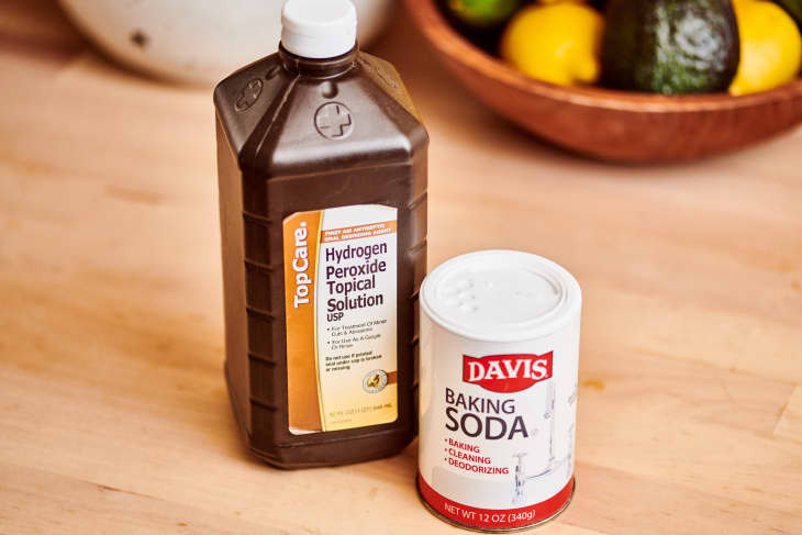 Bottle of hydrogen peroxide and can of baking soda on kitchen counter
