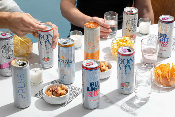 Various spiked seltzer brands laid out on table.