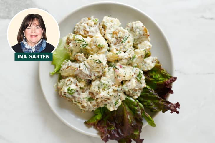 Potato salad with dill and lettuce on a white plate, featuring a portrait of Ina Garten.