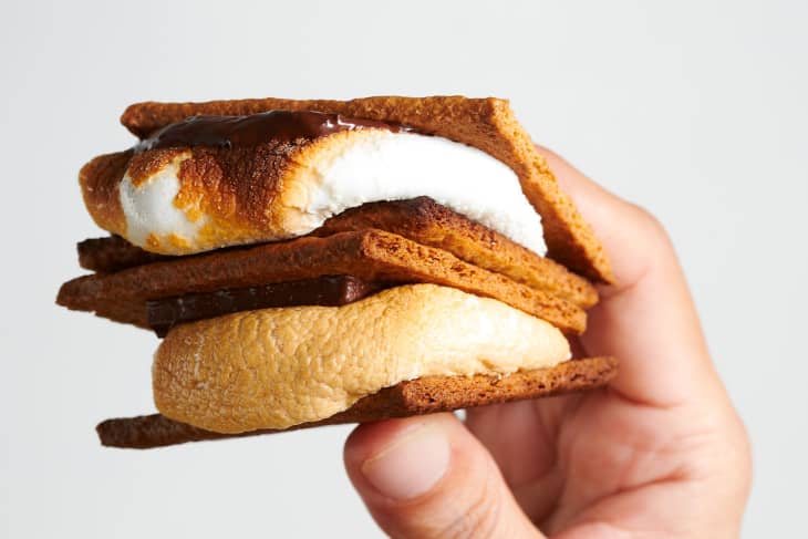 A hand holds two s'mores.