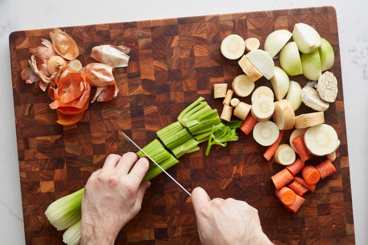 someone is chopping celery on a cutting board