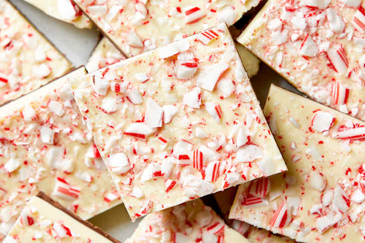Overhead shot of pieces of peppermint bark, topped with crumbled candy cane.