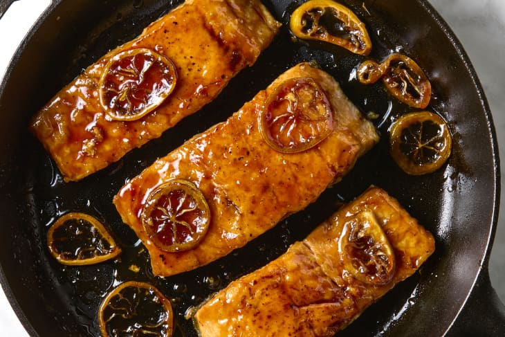 overhead shot of three pieces of lemon soy glazed salmon in a cast iron.