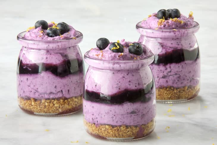 angled shot of three small jars of blueberry mousse, topped with lemon zest and small blueberries