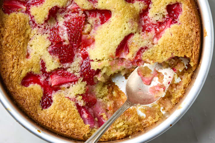 overhead shot of strawberry spoon cake with a scoop taken out of it with a spoon resting in it