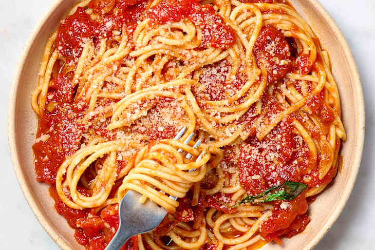 overhead shot of spaghetti marinara on a plate, topped with parmesan